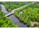 Scenic aerial view of a charming home nestled amidst trees near a bridge over a peaceful river at 100 Canal Rd, Saint George, SC 29477