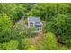 Aerial view of a two-story house surrounded by lush trees, showcasing a large porch and a driveway at 100 Canal Rd, Saint George, SC 29477