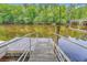 Waterfront property with a wooden dock and metal railings overlooking the river at 100 Canal Rd, Saint George, SC 29477