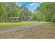 Exterior view of a house on a large lot with a boat shelter and room for parking at 100 Canal Rd, Saint George, SC 29477