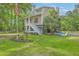 Charming elevated home with a well-manicured lawn and patriotic decor at 100 Canal Rd, Saint George, SC 29477