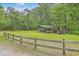 A grassy lot with a boat shelter, surrounded by a wooden fence and trees at 100 Canal Rd, Saint George, SC 29477