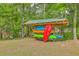 Outdoor kayak storage rack with colorful kayaks, surrounded by lush greenery at 100 Canal Rd, Saint George, SC 29477