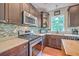 The kitchen boasts stainless steel appliances, mosaic backsplash, and dark wood cabinetry at 100 Canal Rd, Saint George, SC 29477