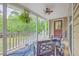 Inviting porch with a ceiling fan, wood railings, and a view of green forest at 100 Canal Rd, Saint George, SC 29477