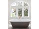 Claw foot tub in light and bright bathroom with large window and decorative fixtures at 11 Dalton St, Daniel Island, SC 29492