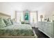 Sun-drenched bedroom boasts a bed, dresser, and a serene art piece over accent chair at 11 Dalton St, Daniel Island, SC 29492