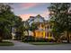 Charming two-story home with double porches, manicured landscaping, and inviting curb appeal at dusk at 11 Dalton St, Daniel Island, SC 29492
