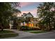 Inviting two-story home with a double porch surrounded by mature trees and lush landscaping at 11 Dalton St, Daniel Island, SC 29492