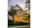 Inviting two-story home featuring double porches, wreath on door, and warm exterior lights at 11 Dalton St, Daniel Island, SC 29492