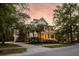 Inviting two-story home with a double porch surrounded by mature trees and lush landscaping at 11 Dalton St, Daniel Island, SC 29492