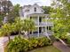 Charming two-story white home featuring double porches, lush landscaping, and a welcoming entrance at 11 Dalton St, Daniel Island, SC 29492