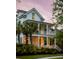 Two-story home with inviting front porches, lush tropical landscaping, and classic architecture at 11 Dalton St, Daniel Island, SC 29492