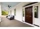 Inviting front porch with ceiling fan, outdoor seating, and decorative front door at 11 Dalton St, Daniel Island, SC 29492