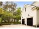 Two-car garage with black doors adds curb appeal and convenience to this beautifully landscaped home at 11 Dalton St, Daniel Island, SC 29492