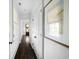Bright hallway with a glimpse of the inviting wood door, white trim and dark hardwood floors at 11 Dalton St, Daniel Island, SC 29492