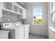 The laundry room is bright and features patterned tile, white cabinets, and new appliances at 11 Dalton St, Daniel Island, SC 29492