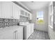 Laundry room featuring patterned tile floors and walls with white cabinets and shelving at 11 Dalton St, Daniel Island, SC 29492