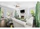 Bright and airy living room with a fireplace, white couch, and french doors to the outside at 11 Dalton St, Daniel Island, SC 29492