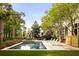 Stunning backyard featuring a pool with spa, lounge chairs, and a serene, landscaped environment at 11 Dalton St, Daniel Island, SC 29492