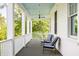 Charming porch with white railings, striped seating, and a tranquil view of the surrounding greenery at 11 Dalton St, Daniel Island, SC 29492