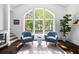 Sun-filled sitting area with comfortable chairs, large windows, and a view of the lush, green backyard and pool at 11 Dalton St, Daniel Island, SC 29492