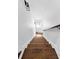 Staircase with hardwood steps and white risers, leading towards a bright window at the end of the hall at 11 Dalton St, Daniel Island, SC 29492