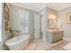 Serene bathroom with a freestanding soaking tub, plantation shutters, and a vanity, creating a tranquil space at 1141 Hills Plantation Dr, Charleston, SC 29412