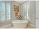 Elegant bathroom featuring a standalone tub, shuttered windows, and decorative wall art at 1141 Hills Plantation Dr, Charleston, SC 29412