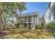 Rear exterior view of a multi-story home with a screened porch and well-maintained lawn at 1141 Hills Plantation Dr, Charleston, SC 29412