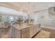 Open kitchen with island, stainless steel appliances, bar seating, and views into the living and dining spaces at 1141 Hills Plantation Dr, Charleston, SC 29412