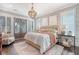 Elegant main bedroom featuring a luxurious bed, stylish chandelier, and french doors to the outside at 1141 Hills Plantation Dr, Charleston, SC 29412