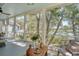 Inviting screened porch with wooden table, comfortable seating, and picturesque views of the surrounding nature at 1141 Hills Plantation Dr, Charleston, SC 29412