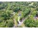 An aerial view of a charming home nestled among mature trees, with a long driveway leading to the main structure at 128 Paul Dr, Summerville, SC 29483