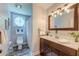 Bathroom featuring a wood vanity, round window, shower with curtains and chrome fixtures at 128 Paul Dr, Summerville, SC 29483