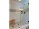 Modern glass shower with a wood bench and neutral-toned tile at 128 Paul Dr, Summerville, SC 29483