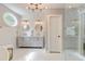 Bright bathroom featuring a double vanity, round mirrors, and modern lighting fixtures and oval window at 128 Paul Dr, Summerville, SC 29483