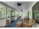 Relaxing screened porch featuring ceiling fans and comfortable wicker seating with a wooded view at 128 Paul Dr, Summerville, SC 29483