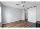 A bright bedroom features a ceiling fan, hardwood floors, and a decorative sliding barn door at 130 River Landing Dr # 4102, Charleston, SC 29492