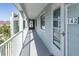 A long balcony hallway featuring an exit sign, metal guardrail, and the door to unit 142 at 142 Marsh View Villas, Folly Beach, SC 29439