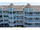 Coastal condo exterior featuring private balconies with tables and chairs perfect for outdoor relaxation at 142 Marsh View Villas, Folly Beach, SC 29439