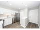 Bright kitchen features stainless steel appliances, white cabinets, and sleek countertops with a view to the entry door at 142 Marsh View Villas, Folly Beach, SC 29439