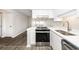 Modern kitchen features stainless steel appliances, white cabinets, and quartz countertops overlooking the living room at 142 Marsh View Villas, Folly Beach, SC 29439