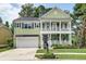 Welcoming two-story house with a double front porch, manicured lawn, and attached two car garage at 149 Daniels Ridge Dr, Summerville, SC 29485