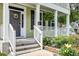 Inviting front porch with hanging ferns, white railings, and a landscaped garden at 149 Daniels Ridge Dr, Summerville, SC 29485