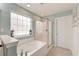 Bright bathroom with a large window, soaking tub, glass enclosed shower, and tile flooring at 149 Daniels Ridge Dr, Summerville, SC 29485