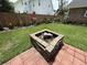 A beautiful backyard features a brick fire pit, lush grass, and a wood fence with stylish plant decor at 1606 Waterside Blvd, Moncks Corner, SC 29461