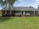 Charming brick home with inviting front porch, rocking chairs, and well-manicured lawn at 1606 Waterside Blvd, Moncks Corner, SC 29461