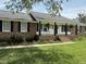 Beautiful brick home featuring a covered front porch, comfortable rocking chairs, and nice landscaping at 1606 Waterside Blvd, Moncks Corner, SC 29461
