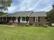 Welcoming single story brick home with a lovely porch, rocking chairs and a well-maintained lawn at 1606 Waterside Blvd, Moncks Corner, SC 29461